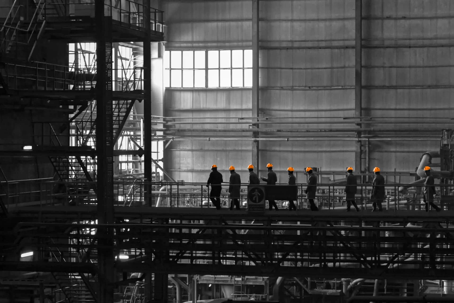 Equipo de operarios con cascos en planta industrial